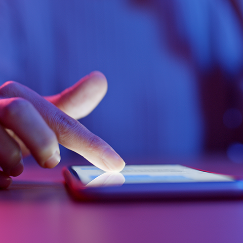 Hand with index finger extended touching phone screen 