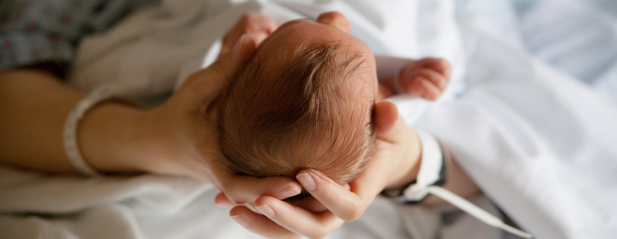New mother holding baby in hospital bad